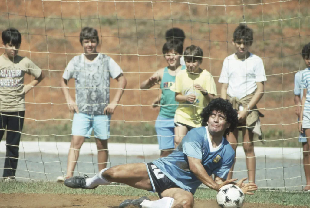 Diego Maradona, observado por crianças brasileiras, em treino da seleção argentina em Goiânia, na Copa América de 1989 - (Nelson Coelho)