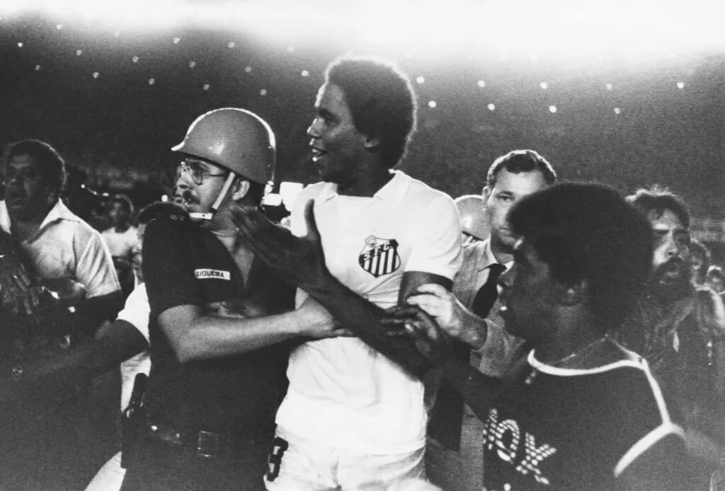 Serginho, do Santos, sendo contido por um policial, durante briga no jogo contra o Flamengo, pela final da Taça de Ouro 83 - (Ignacio Ferreira/PLACAR)