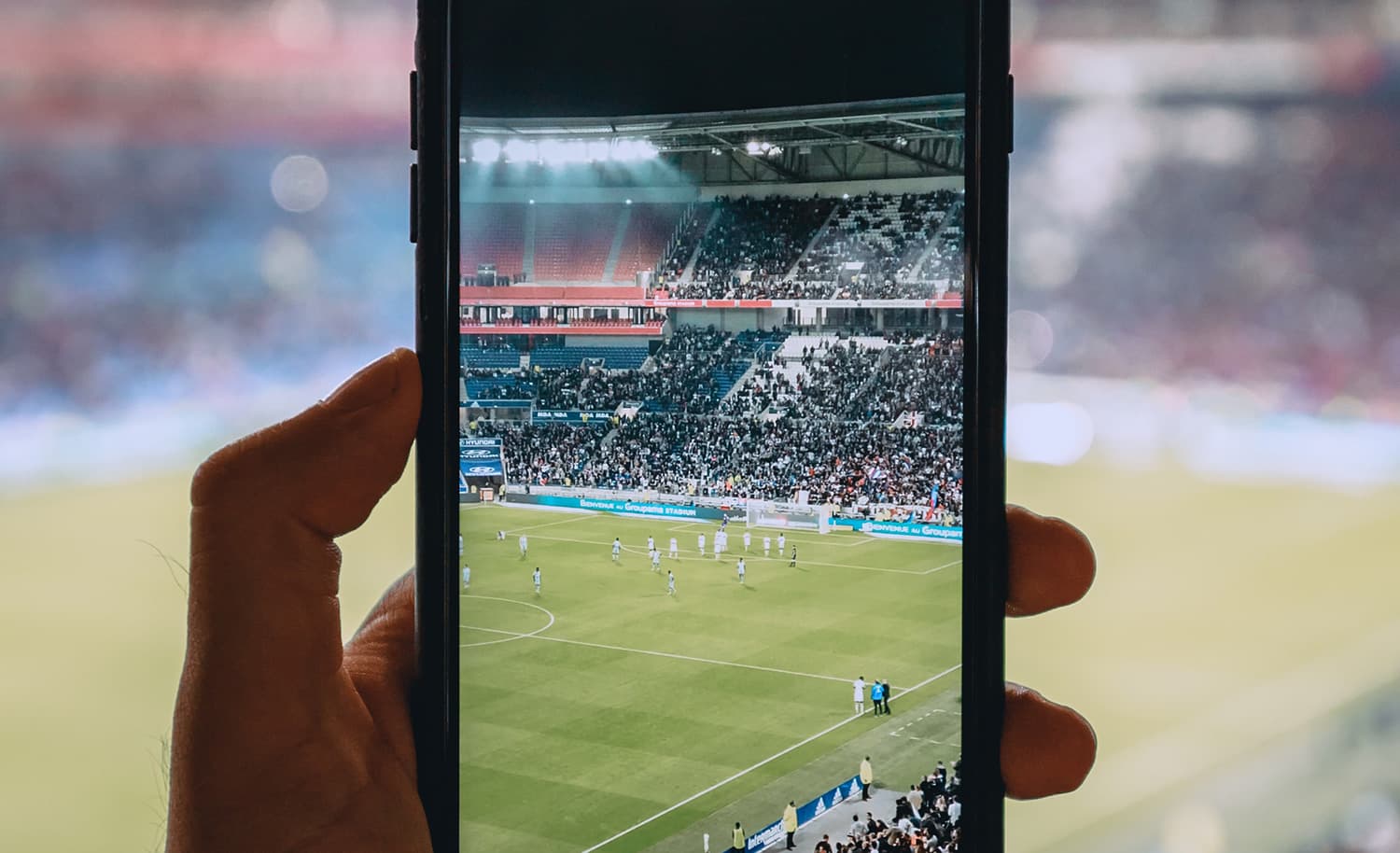 Foto da tela de um celular filmando um campo de futebol