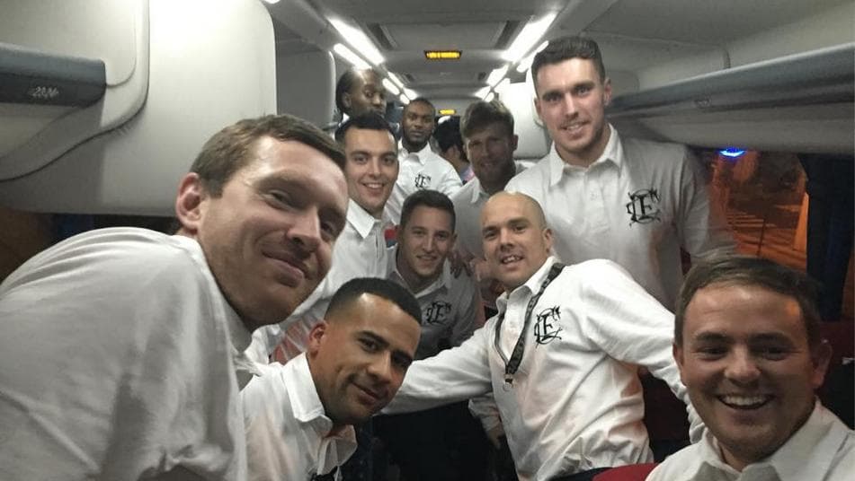 Vestindo uma camisa retrô, atletas do Corinthian-Casuals posam em ônibus, já em São Paulo