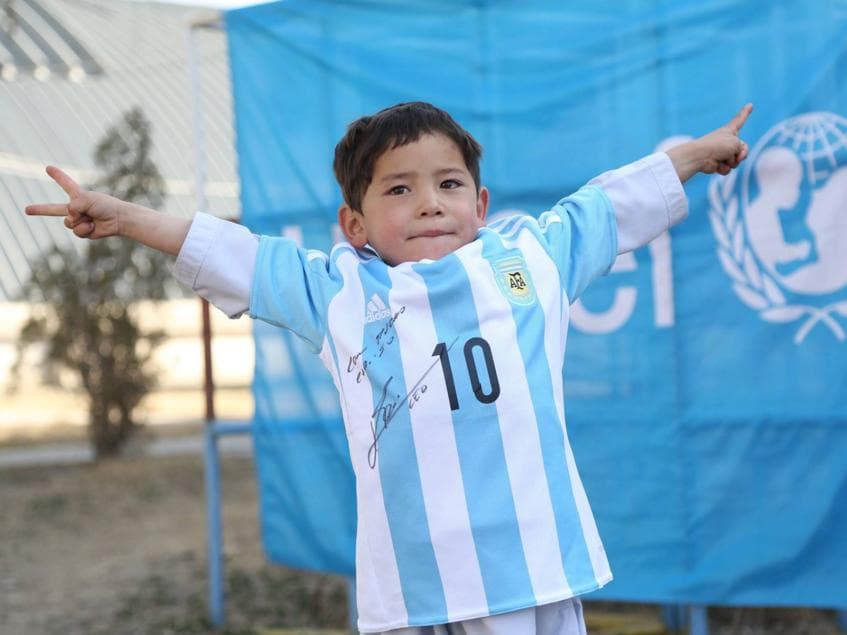 Murtaza Ahmadi, de cinco anos, posa com a camisa da Argentina presenteada por Messi
