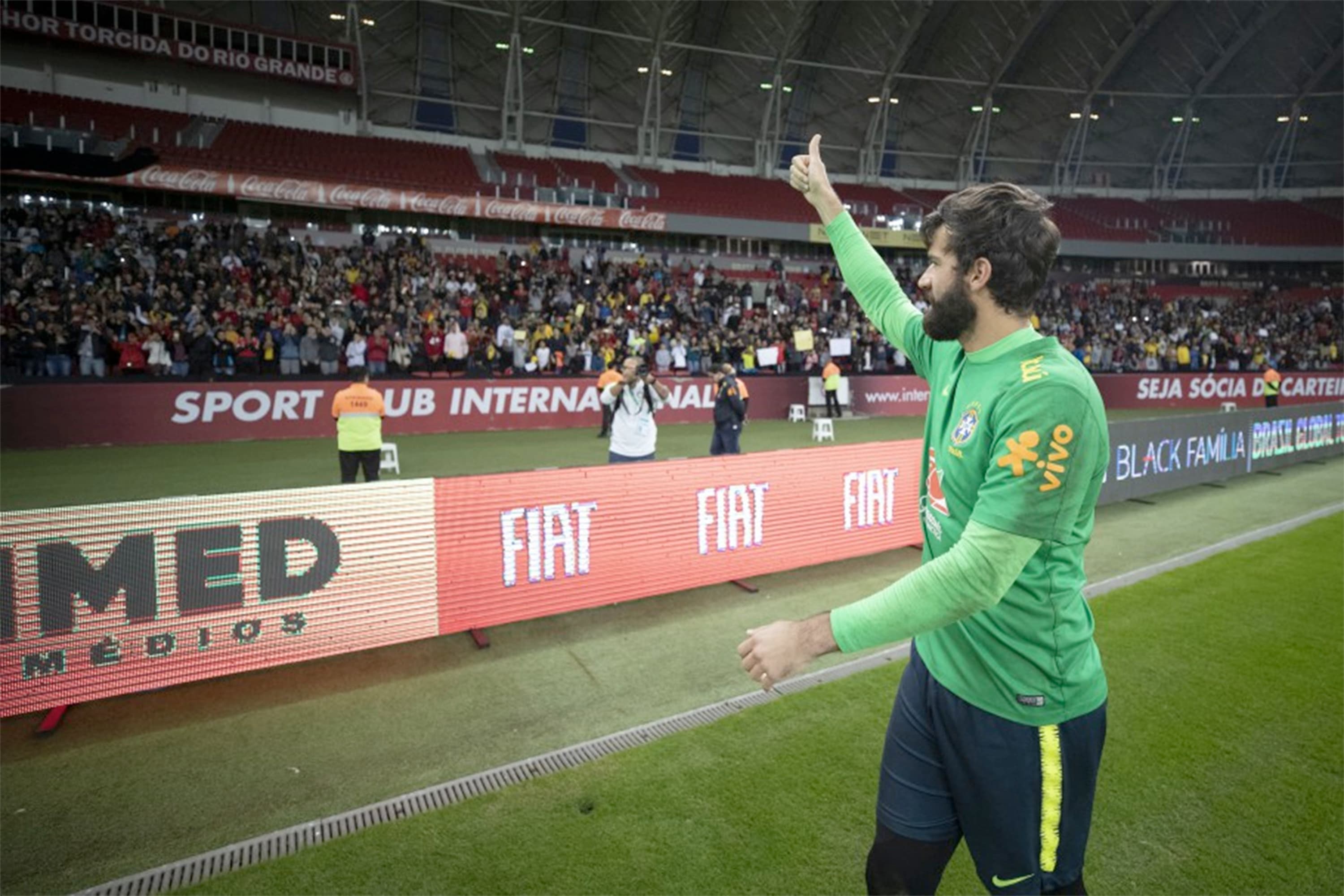 O goleiro Alisson cumprimenta torcedores durante treino da seleção brasileiro no estádio Beira Rio, em Porto Alegre