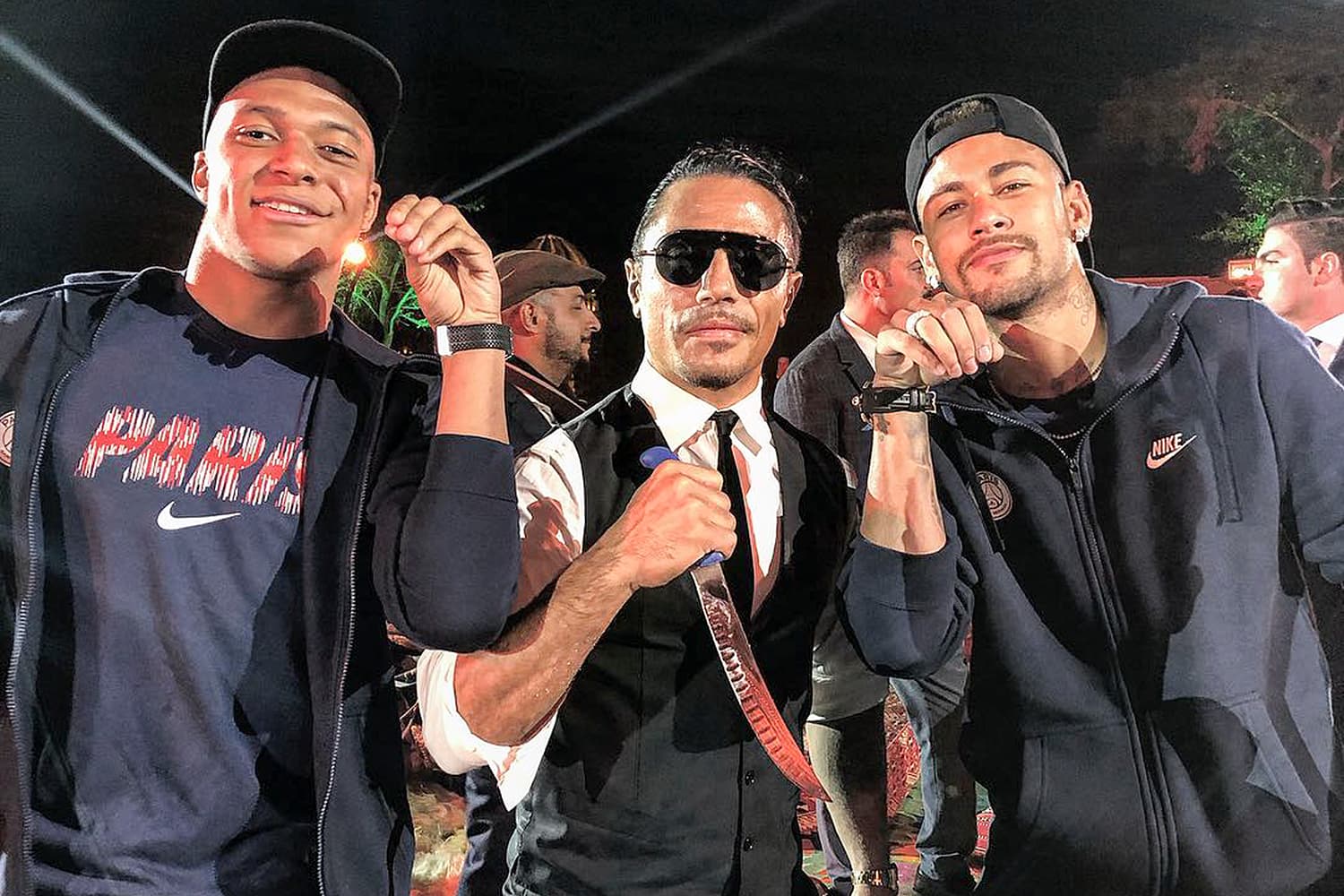 Os jogadores Neymar e Kylian Mbappé posam para foto com o churrasqueiro Nusret Gökçe, conhecido como Salt Bae