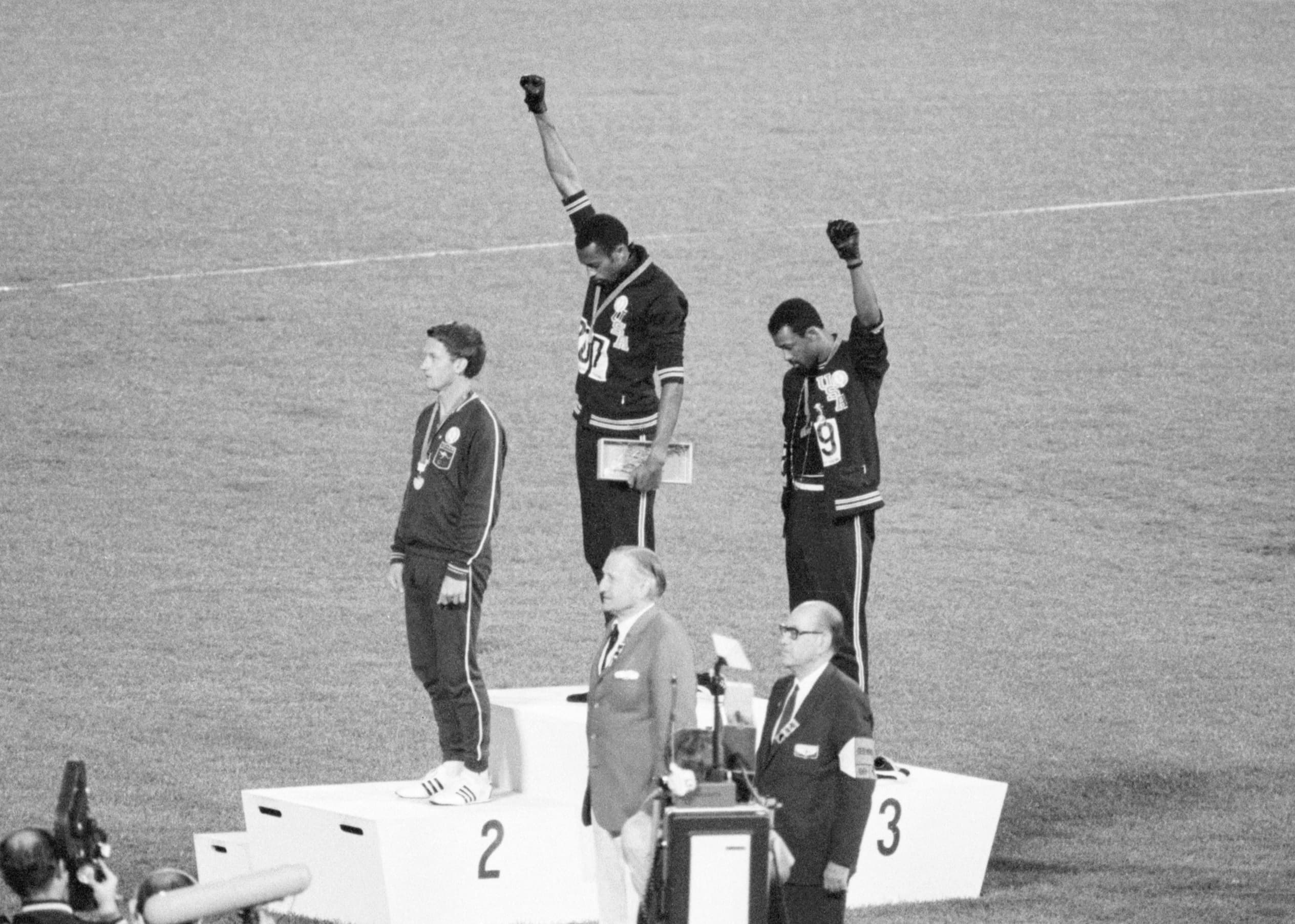 Os atletas americanos Tommie Smith e John Carlos (1º e 3º lugar) fazem sinal em protesto, nas Olimpíadas do México em 1968