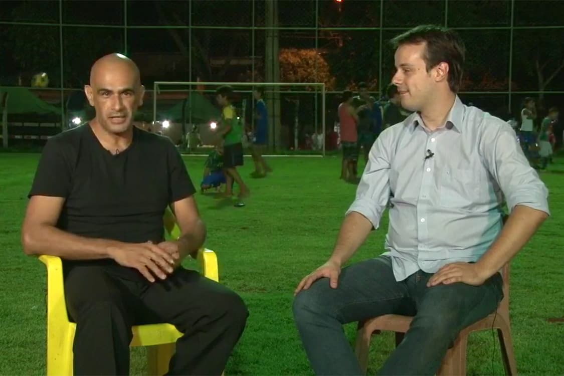 O repórter Alexandre Senechal (à dir.) fala com Carlos Tony, criador do Futebol na Praça, que reúne crianças de todas as idades para ensinar o esporte