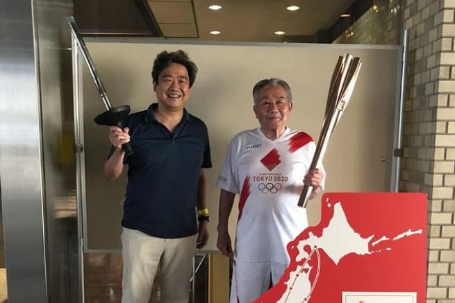 Roy Tomizawa (`à esq) com o campeão olímpico Shuji Tsurumi: tochas de 1964 e 2021
