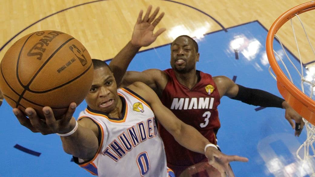 Russell Westbrook, do Oklahoma City Thunder, supera Dwayne Wade, do Miami, e marca dois pontos no primeiro jogo das finais da NBA