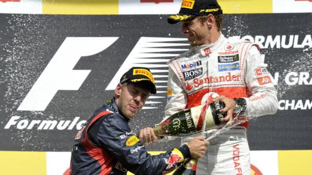 Jenson Button (dir) comemora vitória no GP da Bélgica ao lado do segundo colocado Sebastian Vettel