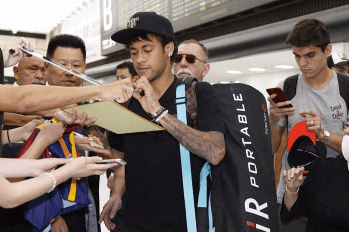 Neymar atende fãs ao desembarcar no aeroporto de Tóquio