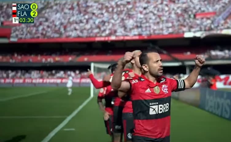 Éverton Ribeiro comemora gol do Flamengo com torcida desfocada ao fundo -