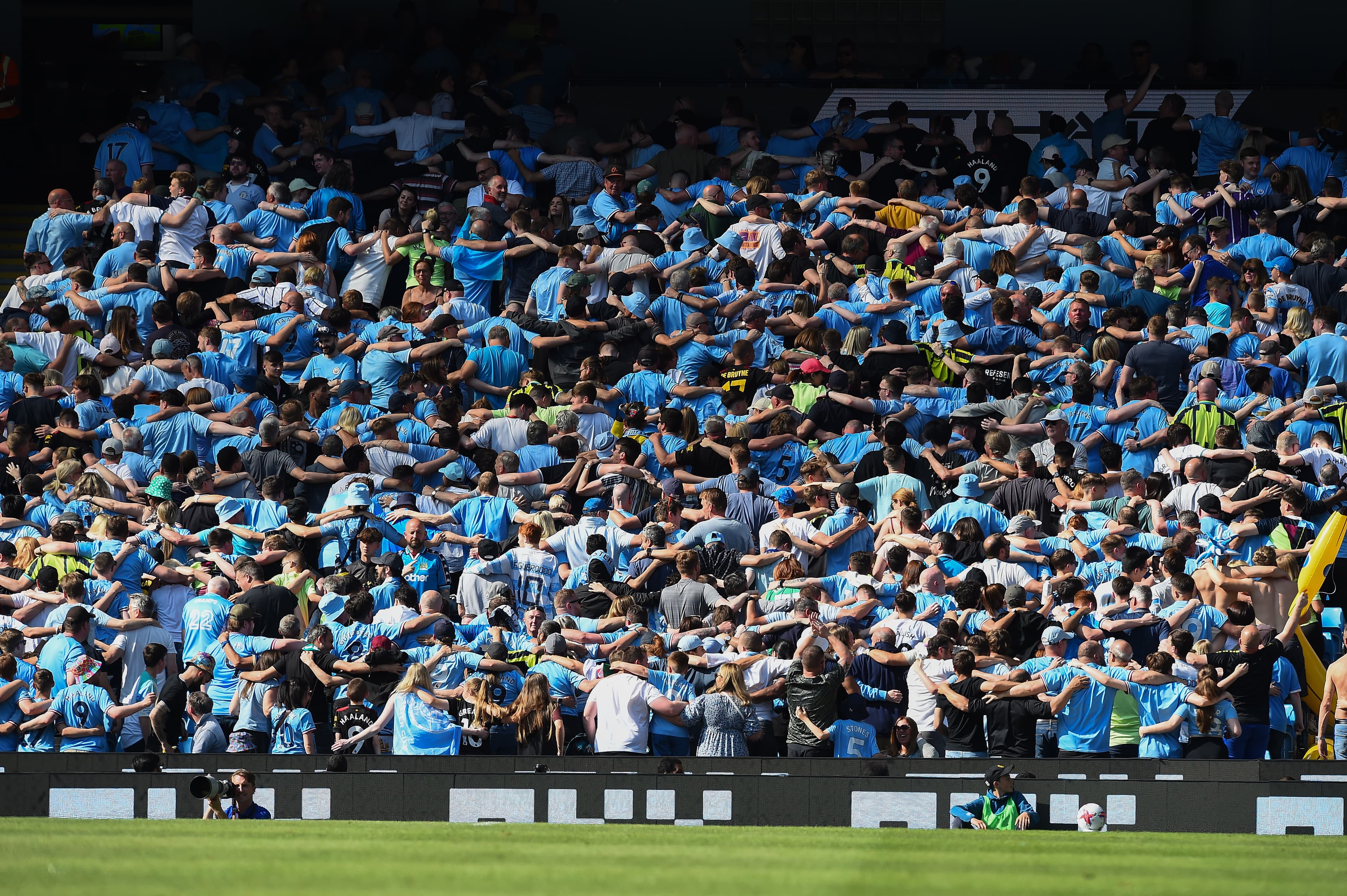 De costas: torcida do Manchester City e sua tradicional celebração no Etihad