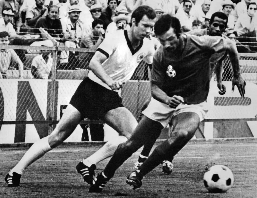 Franz Beckenbauer (à esq.) no jogo entre Alemanha Ocidental e Marrocos, pela Copa do Mundo de 1970 - Staff/AFP