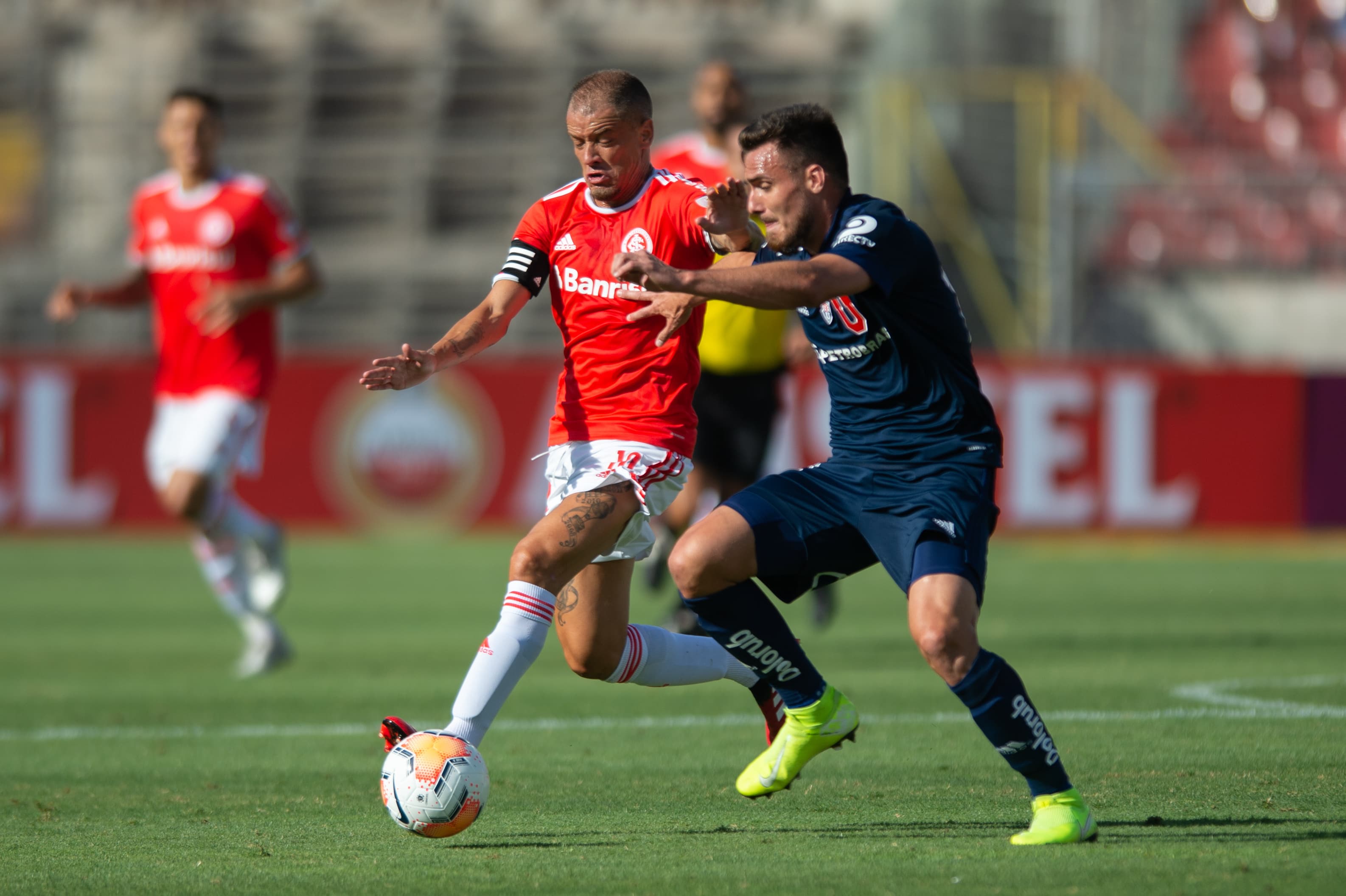 Moya da Universidad de Chile disputa lance com D’Alessandro do Internacional, durante a partida de ida da Pré-Libertadores 2020, no Estádio Nacional do Chile