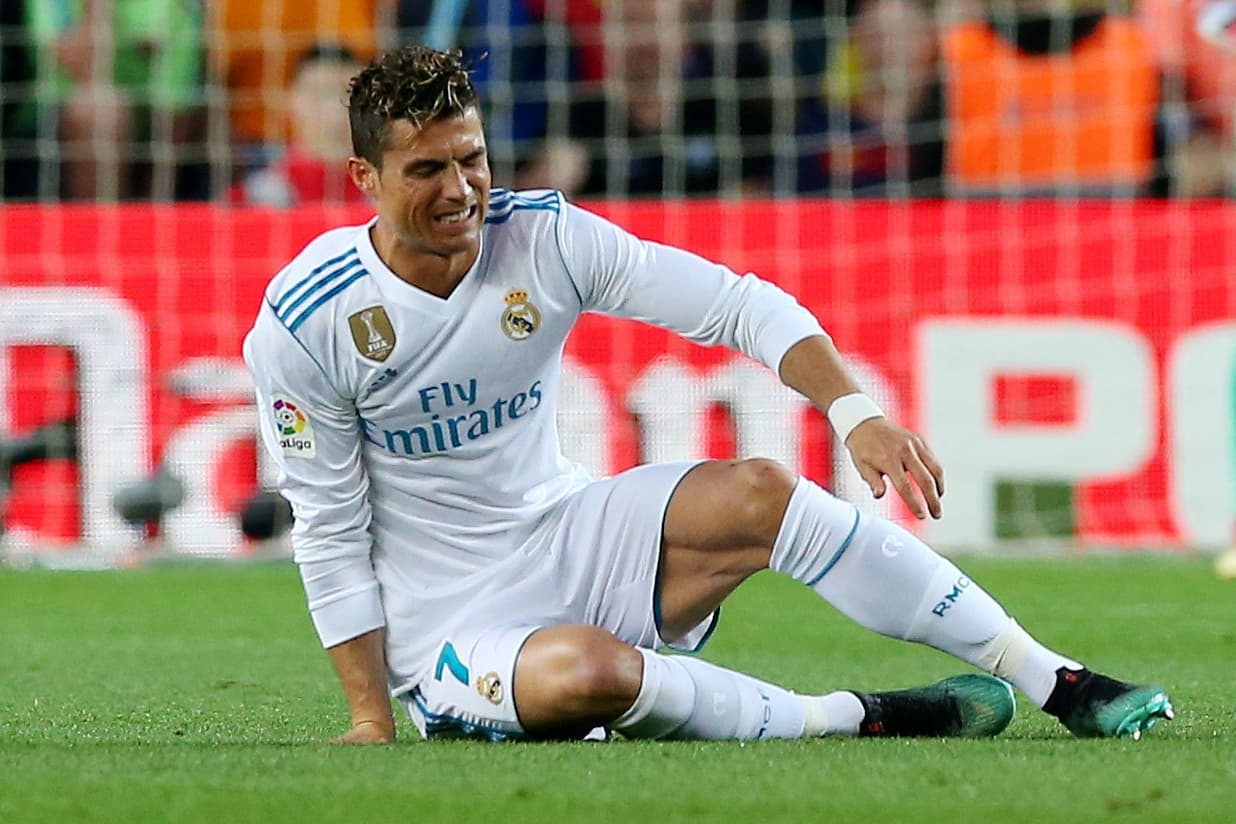 O atacante português Cristiano Ronaldo do Real Madrid sofre lesão durante partida contra o Barcelona, válida pelo Campeonato Espanhol