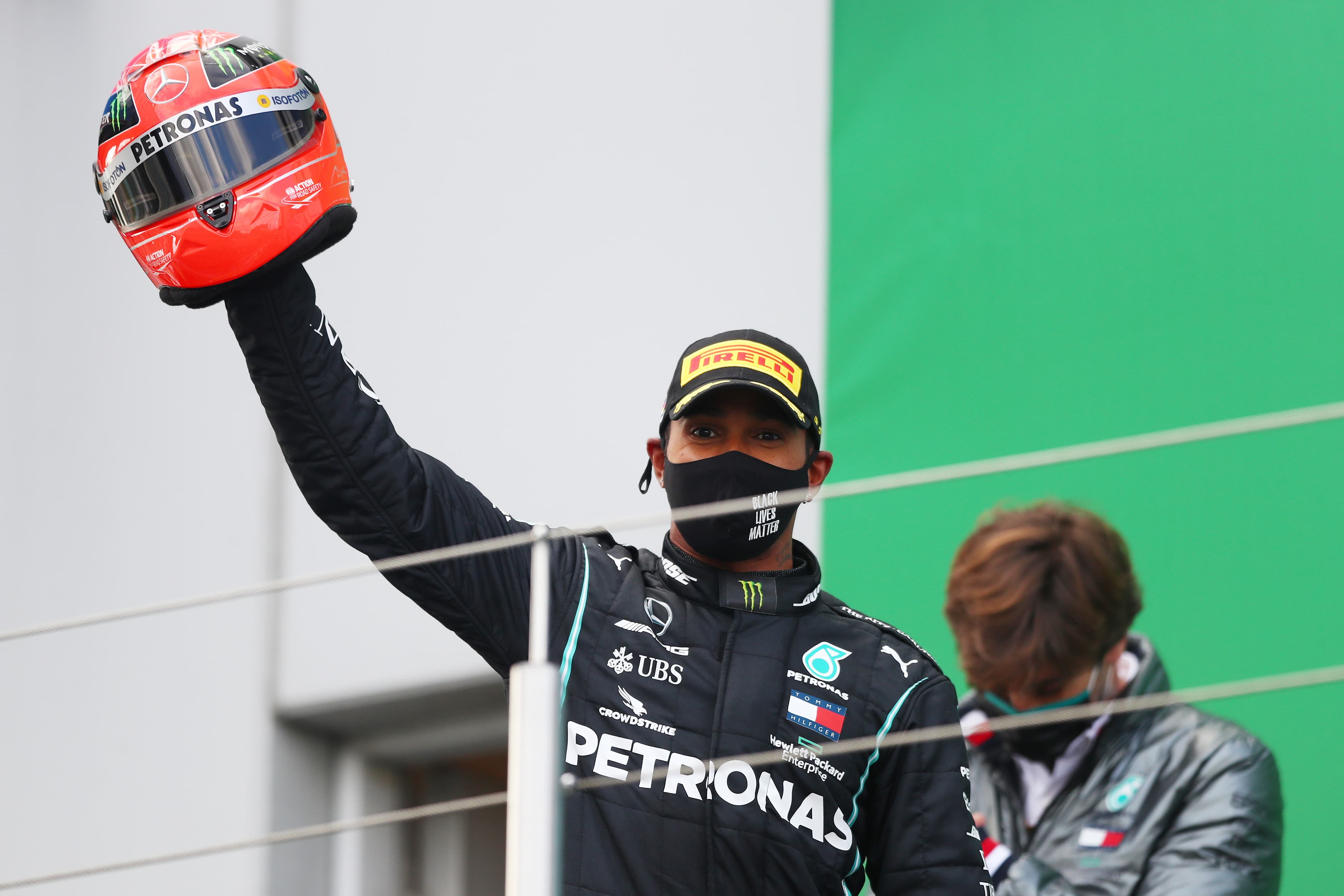 Lewis Hamilton segura a réplica do capacete de Michael Schumacher, que ganhou do filho do ex-piloto alemão, ao igualar o recorde de 91 vitórias
