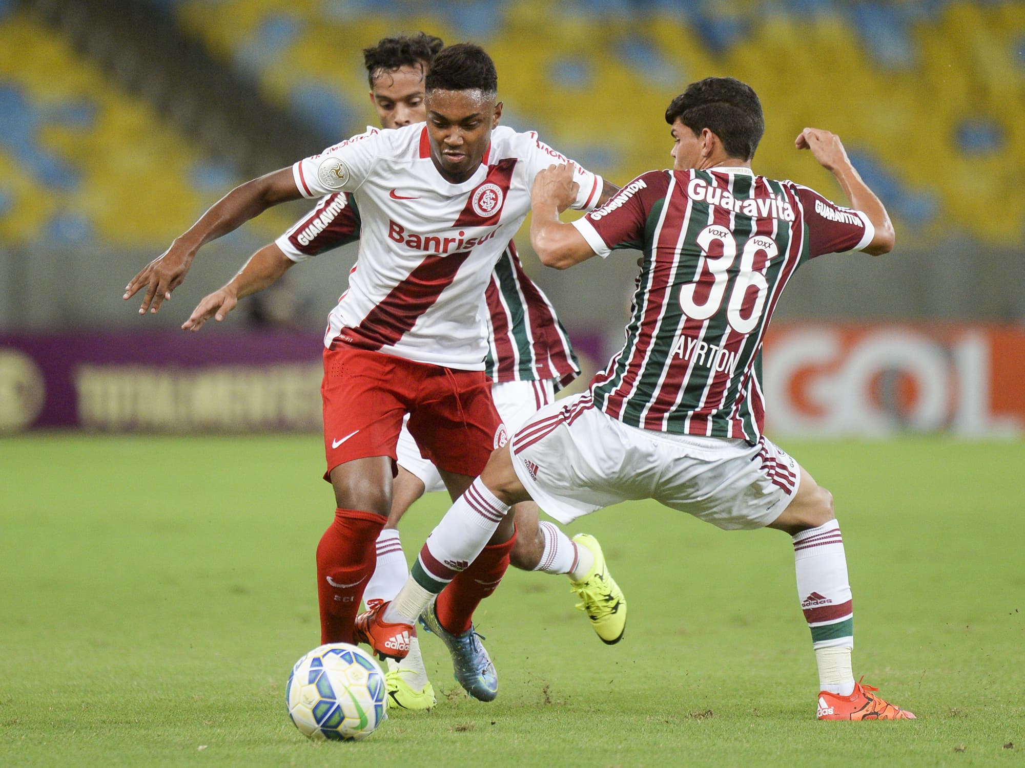 Vitinho e Ayrton disputam pela bola durante a partida entre Fluminense e Internacional, neste sábado (28), no Maracanã