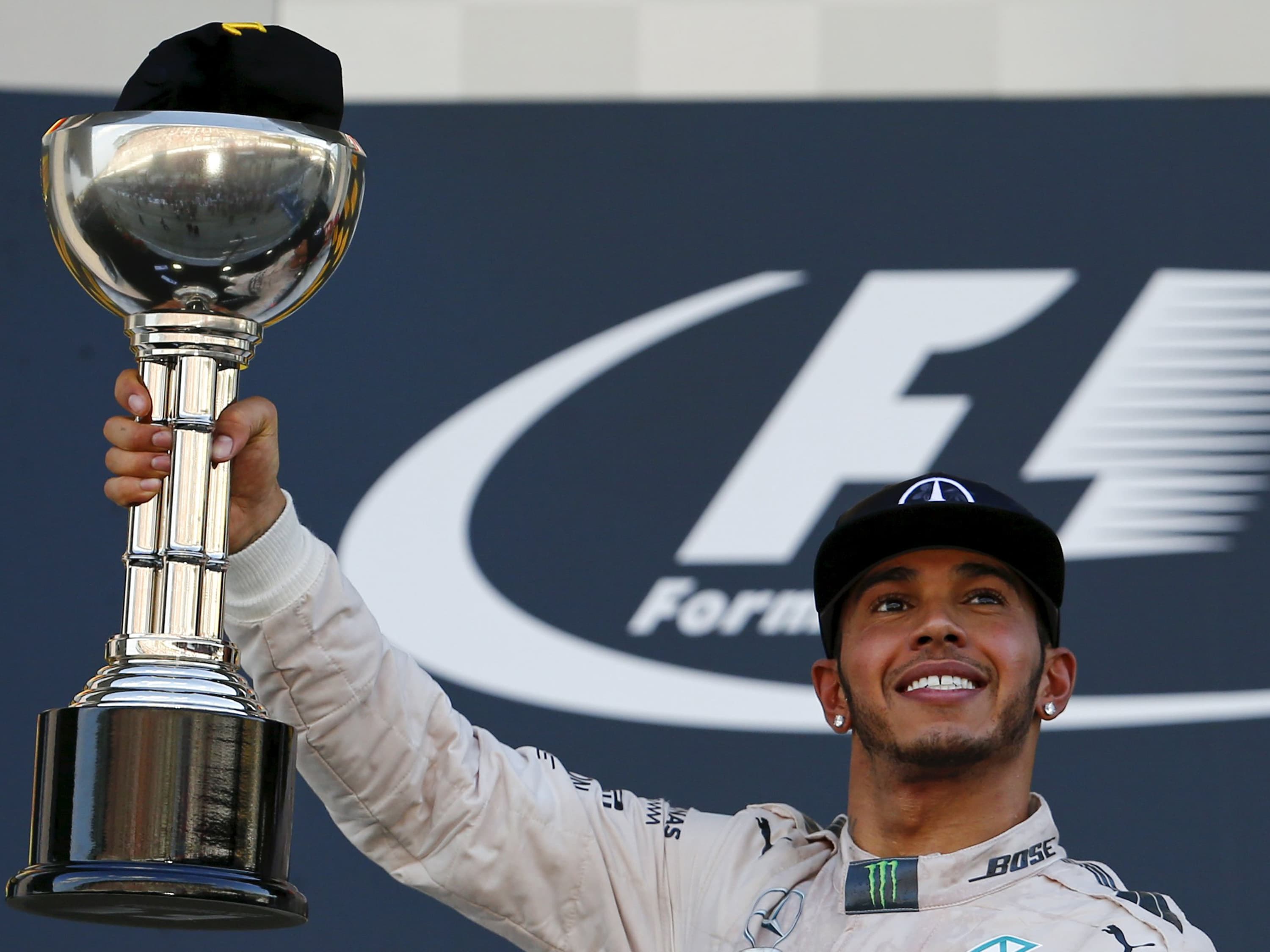 Piloto da Mercedes, Lewis Hamilton, segura seu troféu após vitória no Grand Prix japones no circuito de Suzuka