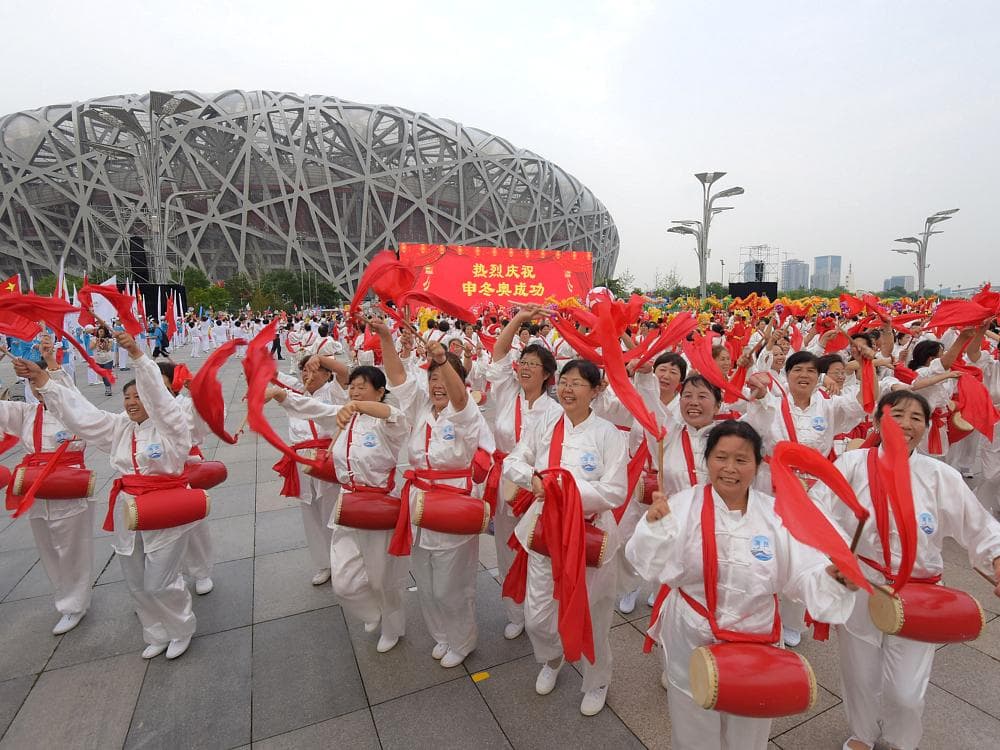 Chineses celebram a escolha de Pequim como sede dos Jogos de Inverno de 2022 em frente ao Estádio Olímpico Ninho de Pássaro