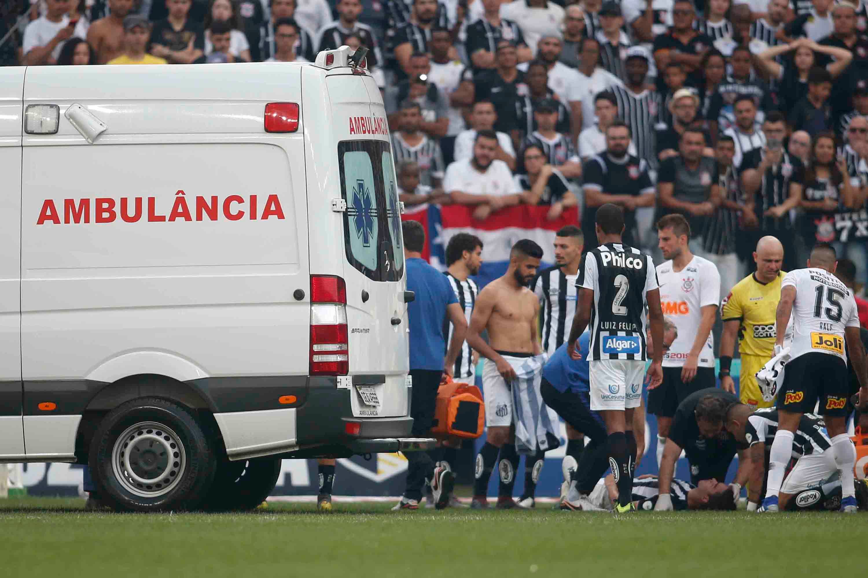 O zagueiro Felipe Aguilar do Santos recebe atendimento médico após choque de cabeça com Danilo Avelar do Corinthians