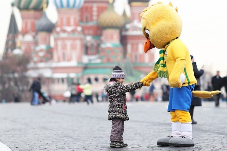O canarinho - mascote da Seleção Brasileira - cumprimenta garota próximo da Catedral de São Basílio, em Moscou, capital da Rússia, faltando 84 dias para o início da Copa do Mundo no país - 22/03/2018