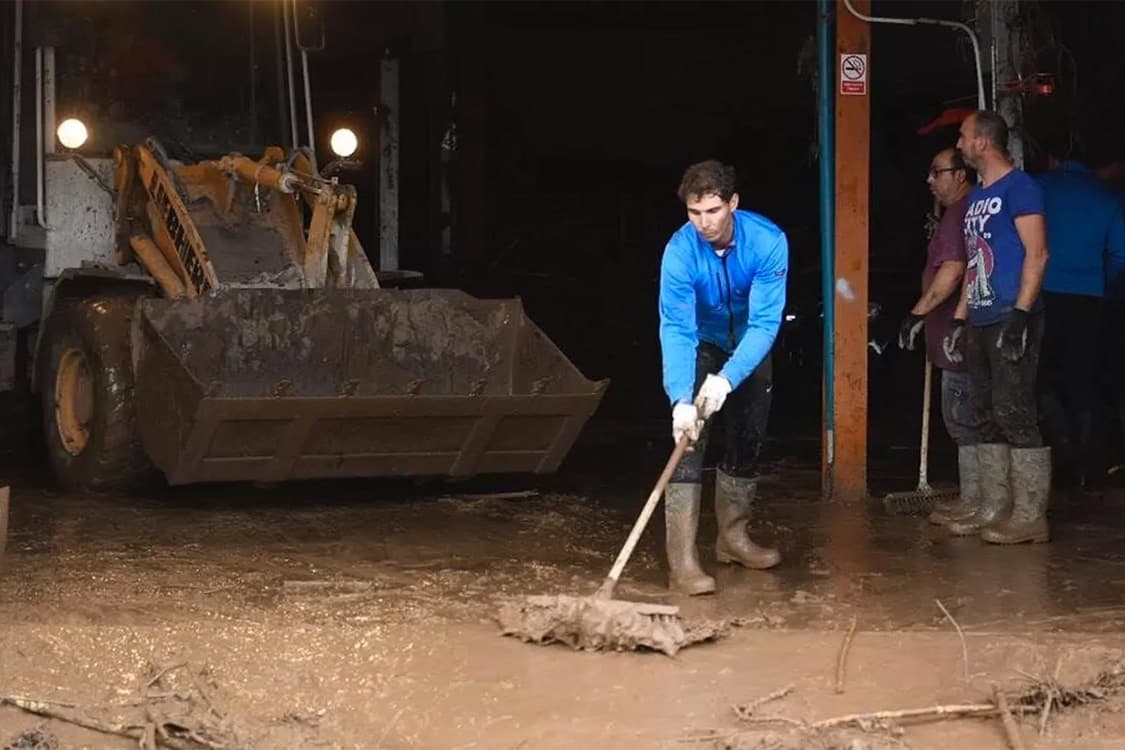 O tenista número 1 do mundo Rafael Nadal, ajuda a retirar a lama arrastada pelas fortes chuvas na cidade de Mallorca, na Espanha