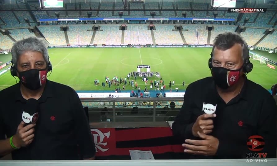 Os comentaristas Alexandre Tavares e Raul Plassmann, da FlaTV, com os campeões tricolores ao fundo