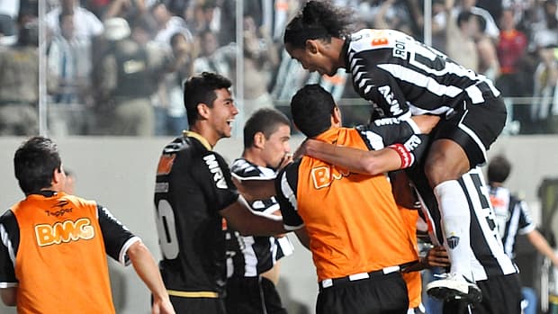 Leonardo e Ronaldinho Gaúcho comemoram gol do Atlético-MG no banco reserva da equipe