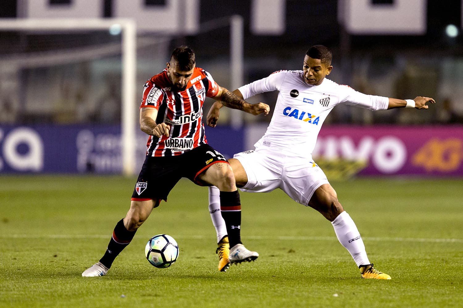 Jogadores disputam a bola na partida entre Santos e São Paulo, na Vila Belmiro