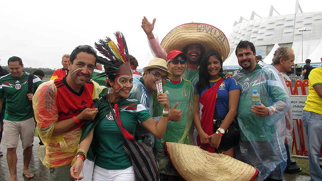 A jornalista Tarciana Alcântara, com a camisa da seleção brasileira, está hospedando seis mexicanos em sua casa: “O jogo do Brasil, eu ouço no rádio”