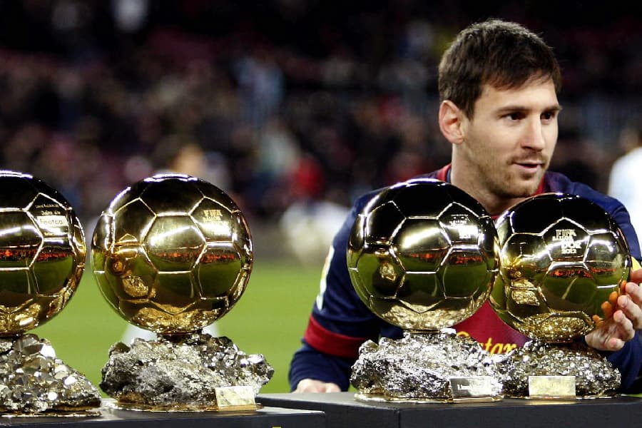 Em 2012, Messi posou ao lado das quatro Bolas de Ouro que ganhou em sequência - Alberto Oliveira/EFE