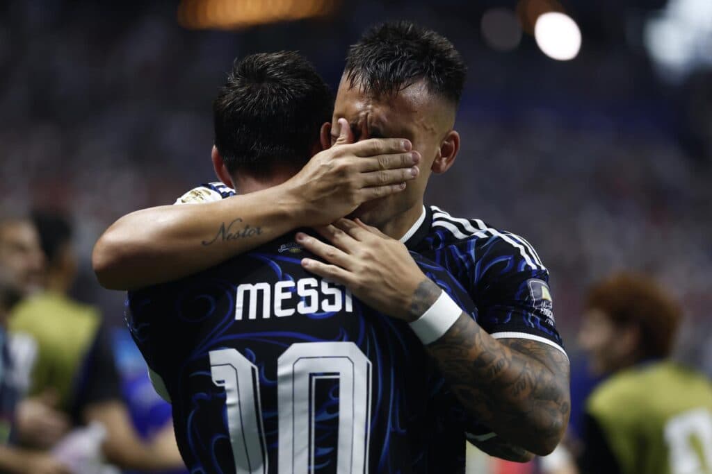 Lautaro Martinez, autor do gol da vitória argentina, abraça Lionel Messi após a partida contra a Inglaterra (EFE/EPA/WILL OLIVER)