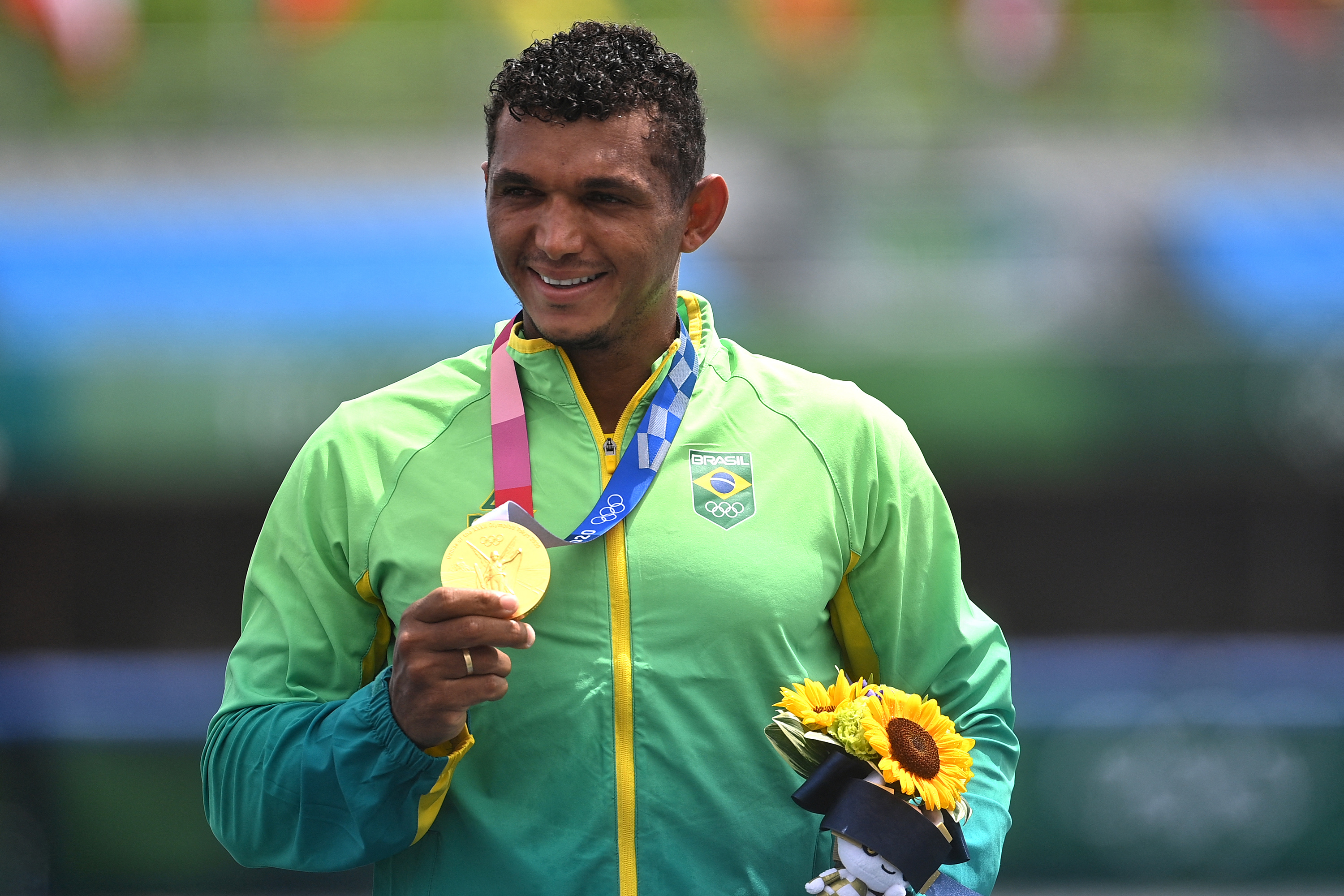 Gold medallist Brazil's Isaquias Queiroz dos Santos celebrates on podium during medals ceremony for the men's canoe single 1000m final during the Tokyo 2020 Olympic Games at Sea Forest Waterway in Tokyo on August 7, 2021. (Photo by Philip FONG / AFP)