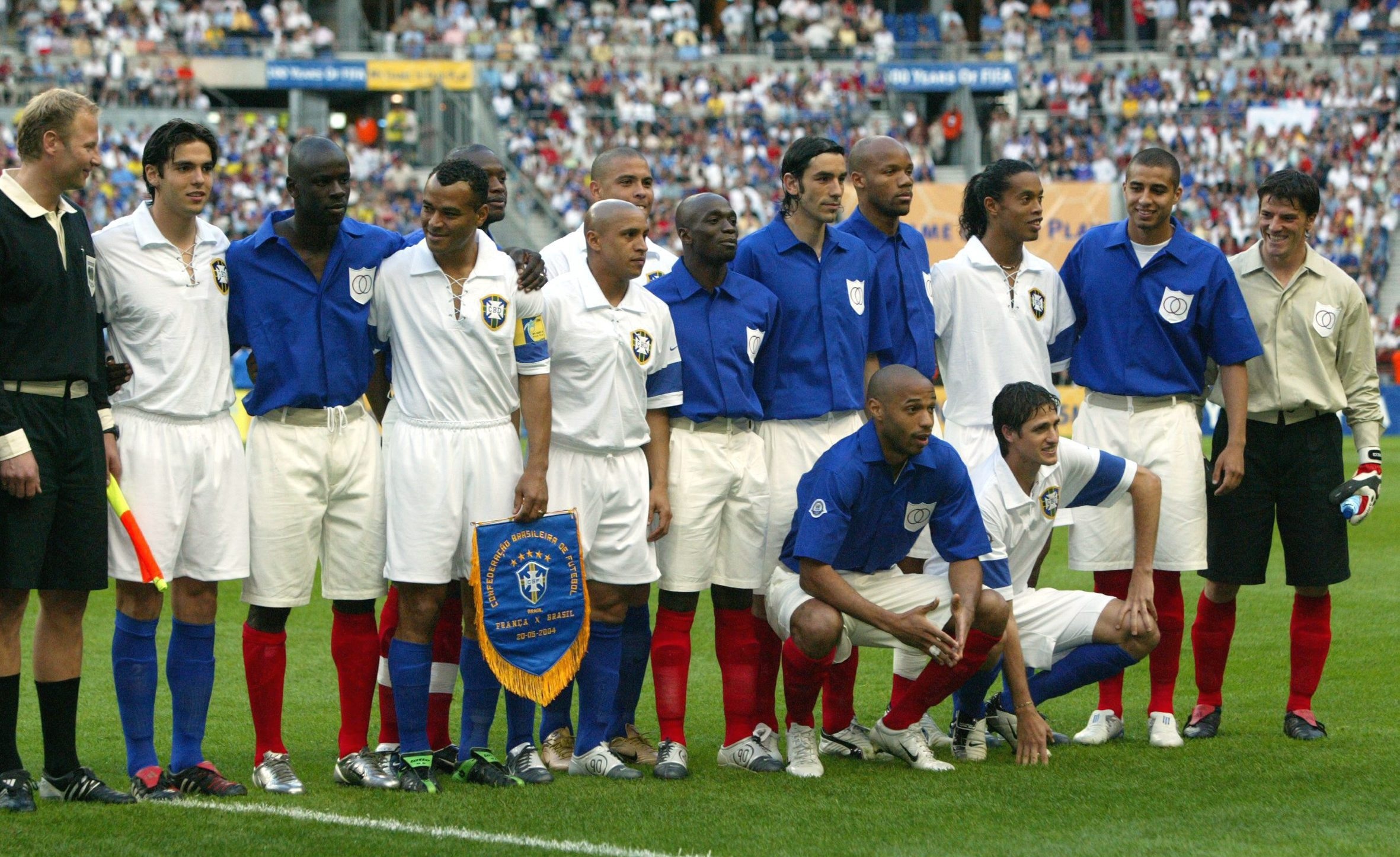 Jogadores de Brasil e França perfilados, com uniformes antigos, no centenário da Fifa em 2004