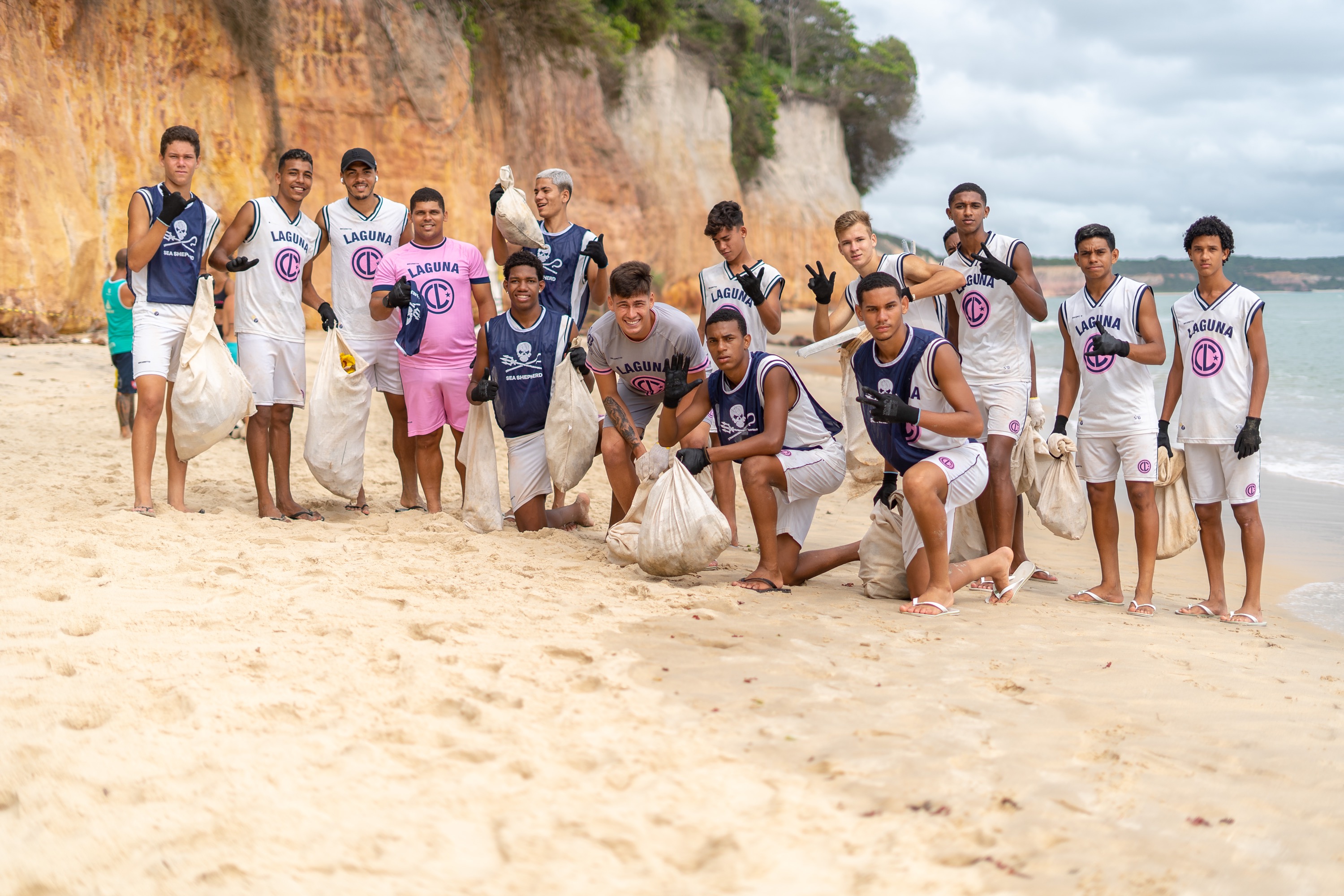 Jogadores do Laguna em ação de limpeza na praia de Pipa, no Rio Grande do Norte