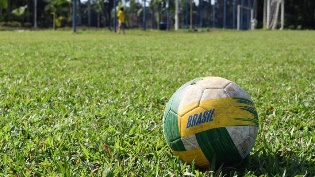 Bola de futebol em um campo no Brasil - Sergio Souza/Unsplash