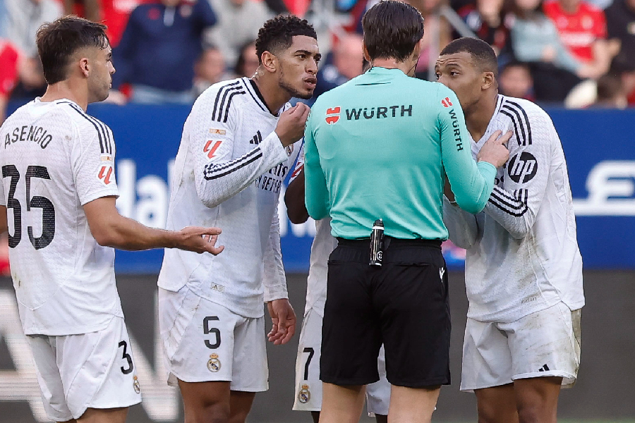 l delantero francés del Real Madrid Kylian Mbappé y su compañero el delantero inglés Jude Bellingham conversan con el el colegiado Munuera Montero, durante el partido de la jornada 24 de la LaLiga EA Sports, disputado este sábado en el estadio el Sadar de Pamplona. EFE/ Villar Lopez