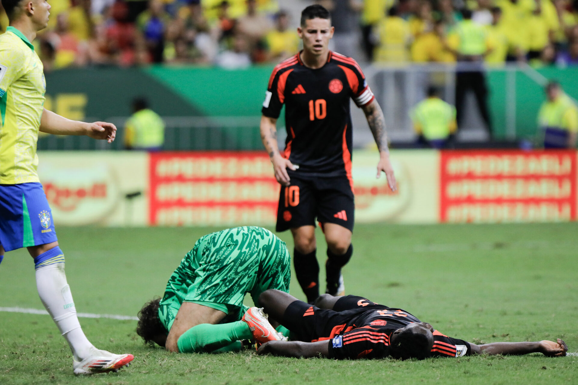 Alisson e Davinson Sánchez estirados no gramado após choque de cabeça - Sergio Lima/AFP